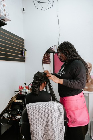 Charlottes oldest daughter, Jazmine Haynes finishing her little sisters hair, Jurnee Haynes. Erin Campbell, OBSERVER